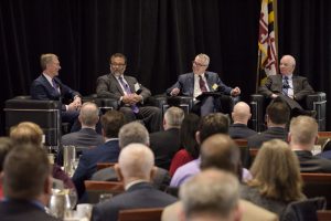 (Left to Right) Leidos Chairman and CEO Roger Krone, NSA Executive Director Harry Coker, Jr., FMA President Steve Tiller and U.S. Senator Ben Cardin sitting in armchairs in front of an audience.